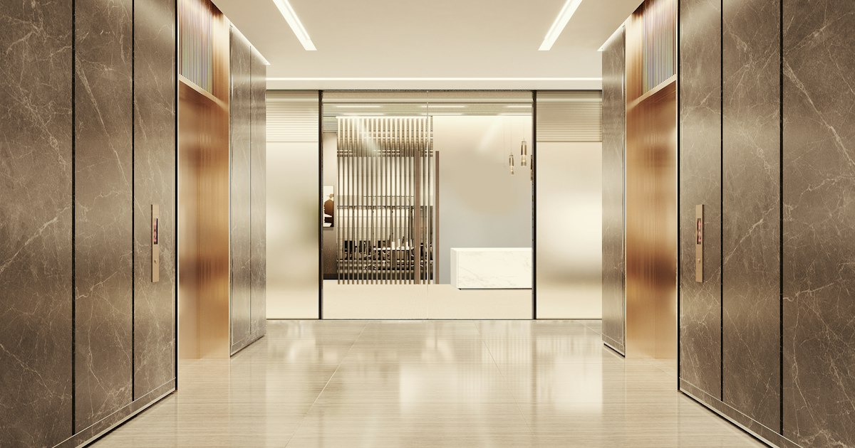 A marble-clad elevator lobby in a professional office building, lit toward frosted glass doors