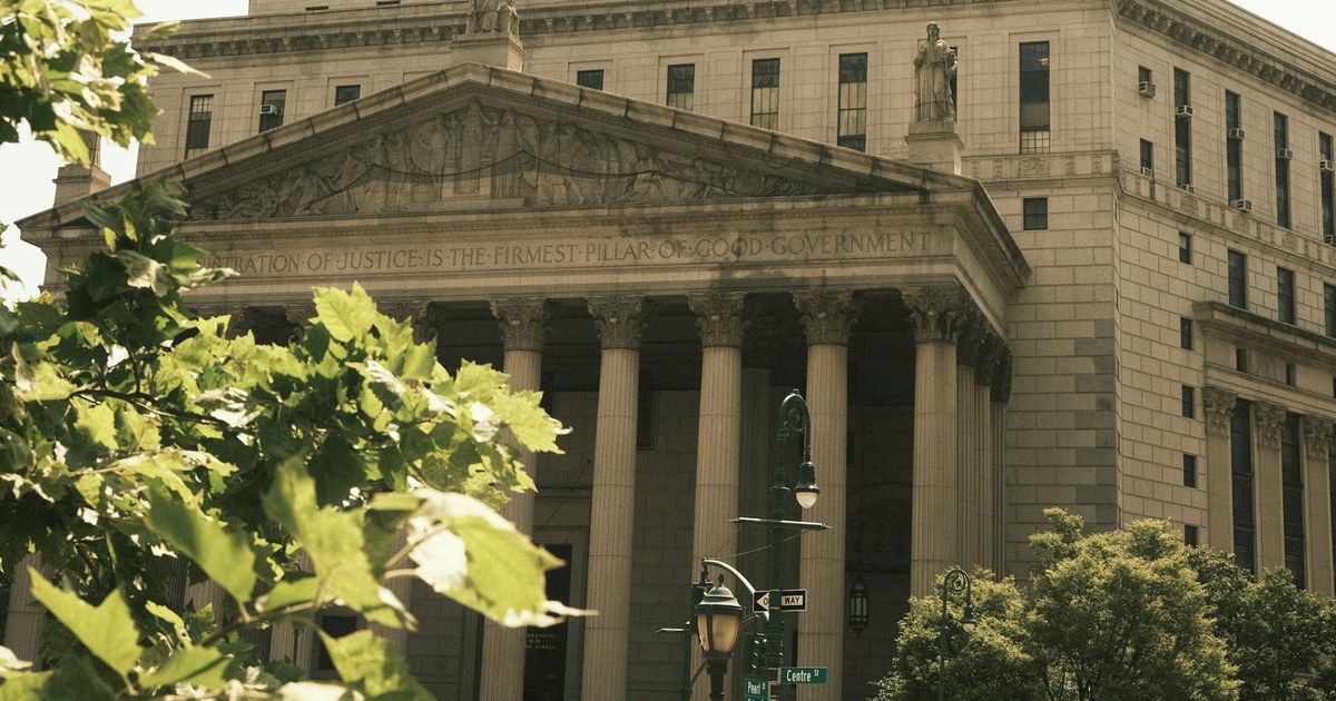 A neoclassical state courthouse portico, its pediment inscribed that the administration of justice is the firmest pillar of good government