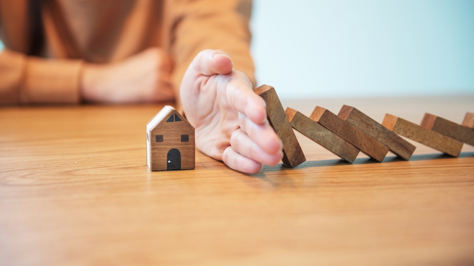 stopping a wooden blocks from falling to a house asset protection concept