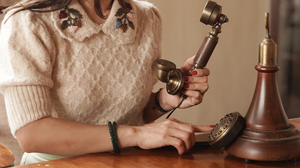 woman holding a vintage telephone