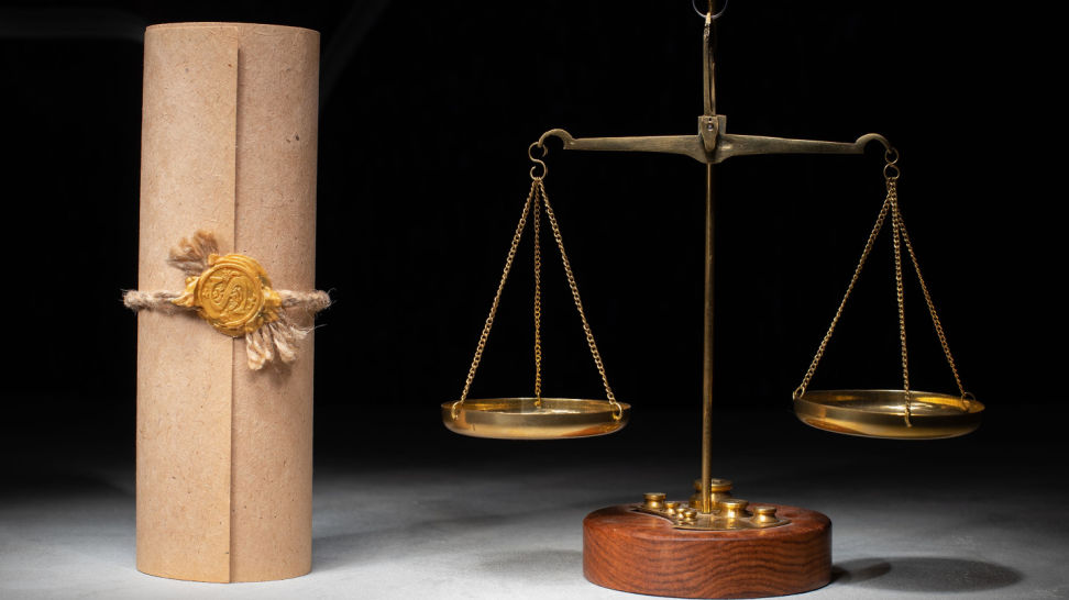 balance scale and bahamian trust document on dark background