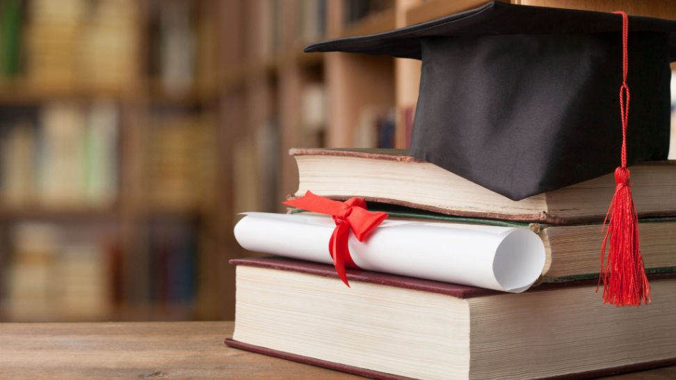 graduation cap diploma and books