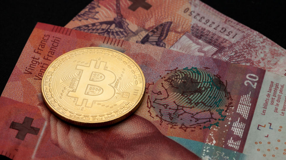 bitcoin cryptocurrency and swiss franc banknotes