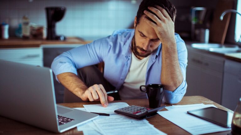 businessman computing his debt in his home