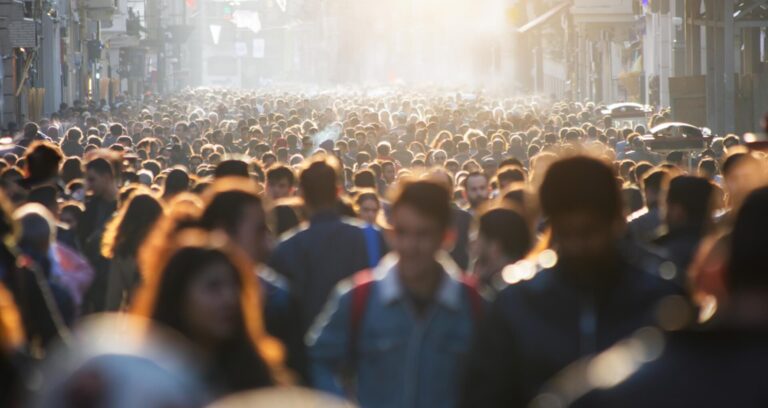 Large crowd of people walking down a city street