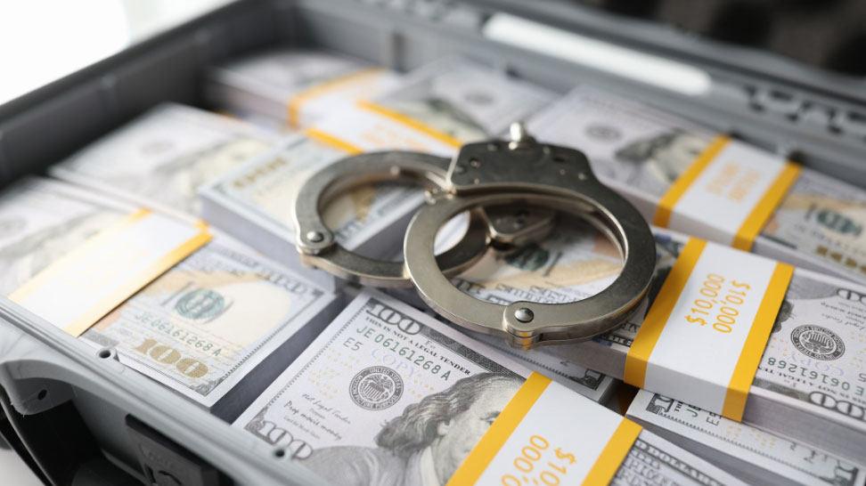 brief case full of dollar bills and handcuffs