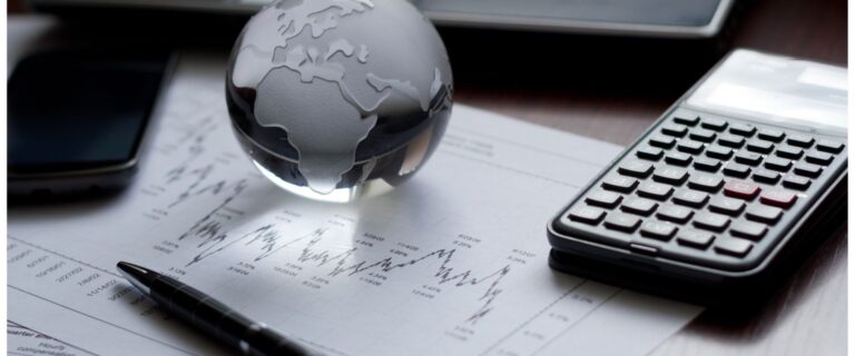 calculator ballpen globe and financial documents in a table