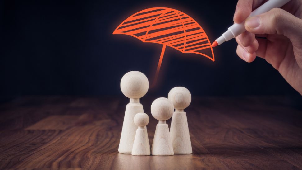 drawing an umbrella on top of a family figurine