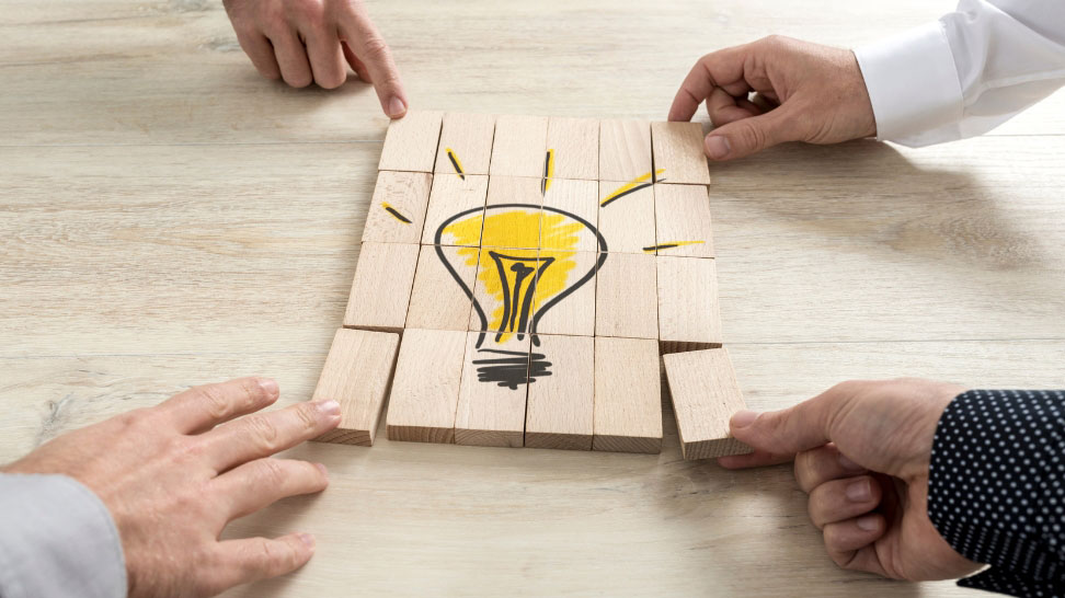 group of people completing light bulb puzzle