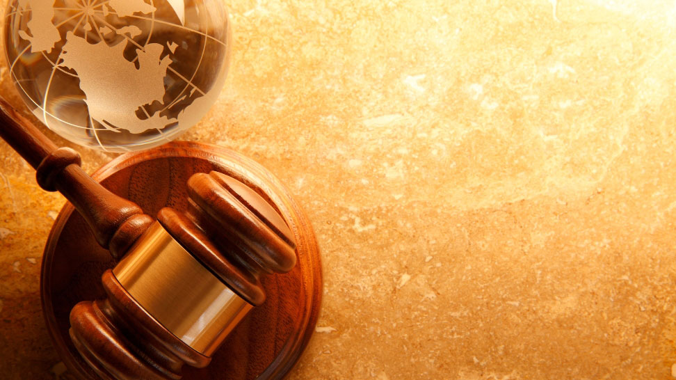 judge gavel and globe on gold background