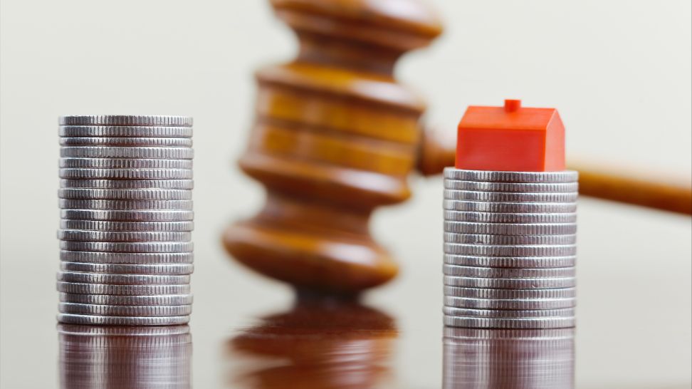 two stack of coins separated with one stack having house at the top