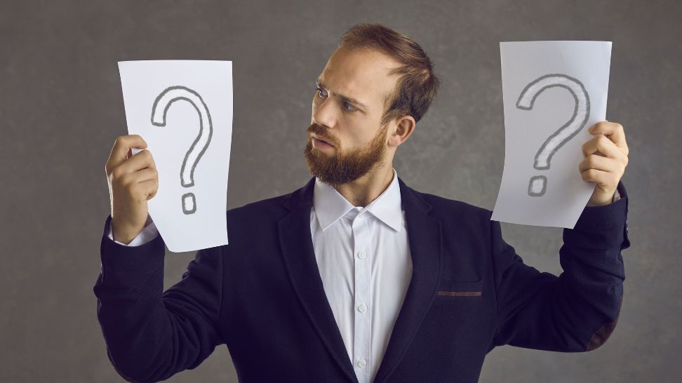 confuse businessman holding two paper with question mark