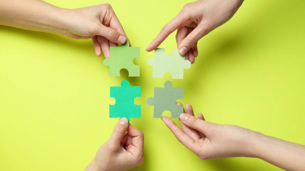 hands combining different color puzzle pieces