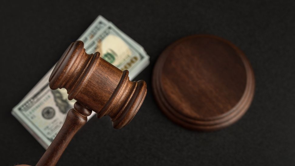 judge gavel with blurred dollar banknotes as background