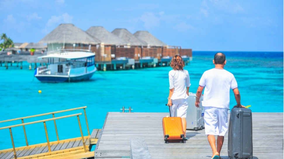 couple walking on pier with luggage