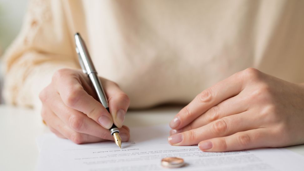 woman signing divorce papers