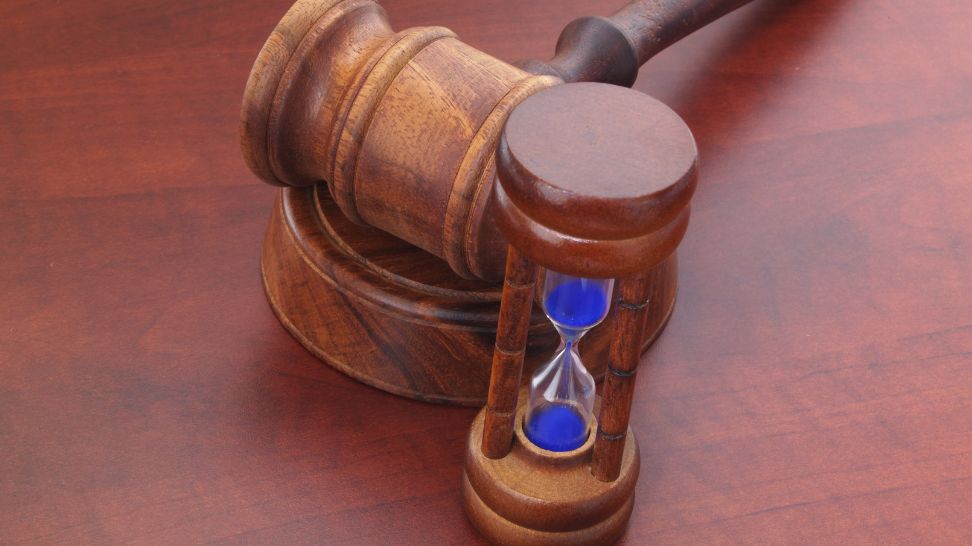 wooden judge gavel and hourglass with blue sand
