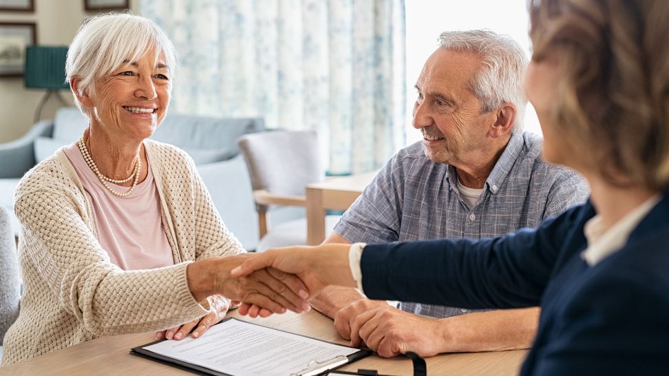 financial advisor shaking hands with an elderly