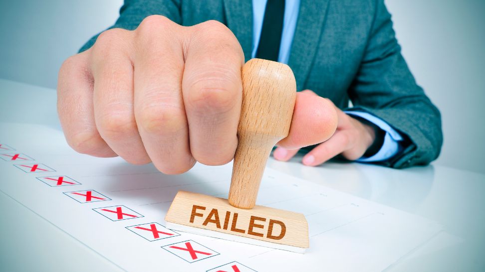 man holding rubber stamp with the word failed