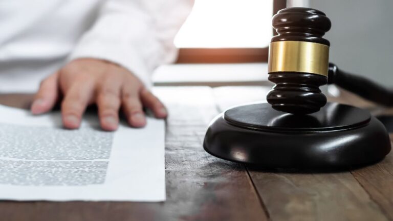 lawyer reading document with gavel on his side