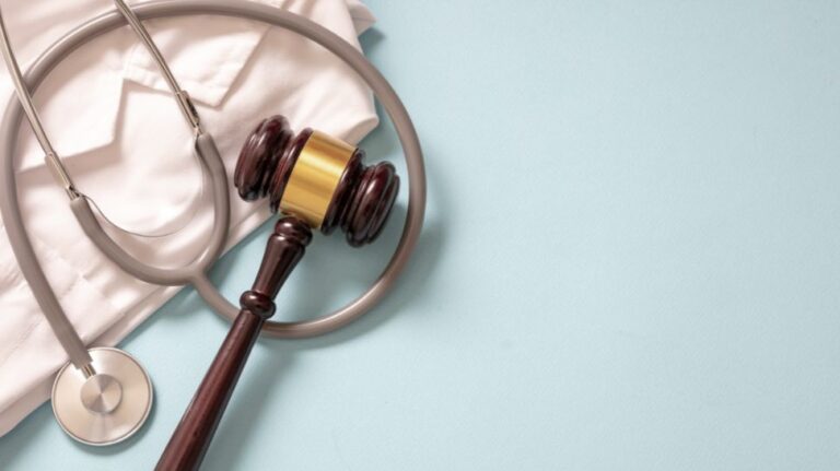 stethoscope and gavel on top of white suit