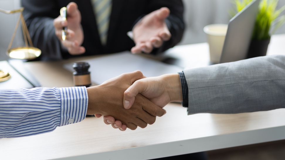 employee and business owner handshake after mediation with lawyer
