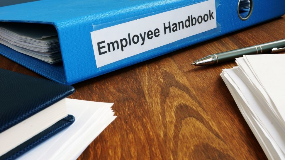 employee handbook manual in folder and documents