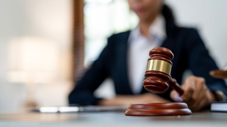 female judge holding gavel on table