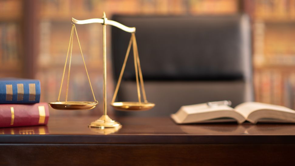 golden justice scale on wooden table