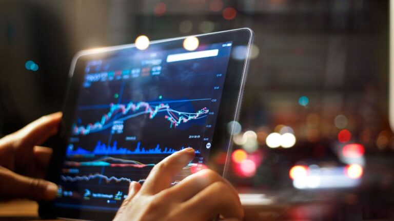 man checking stock market data on tablet