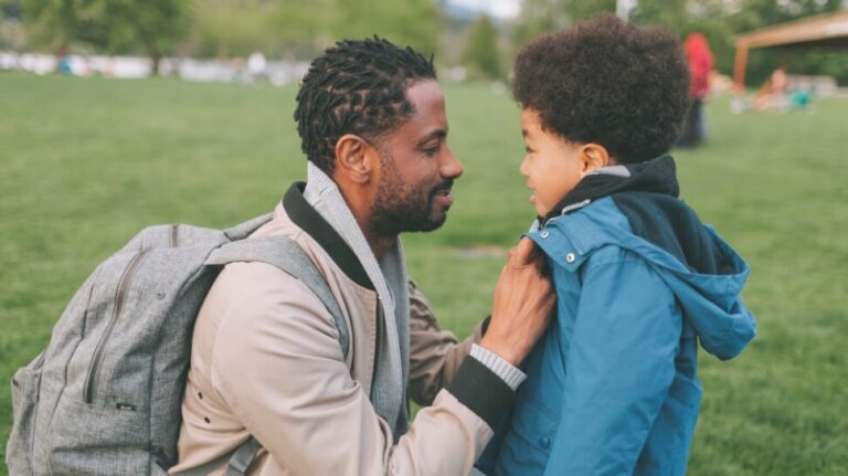 man fixing his child jacket