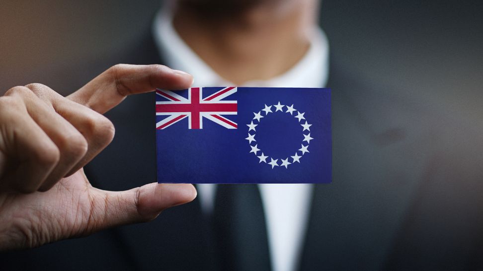 man holding card with cook islands flag