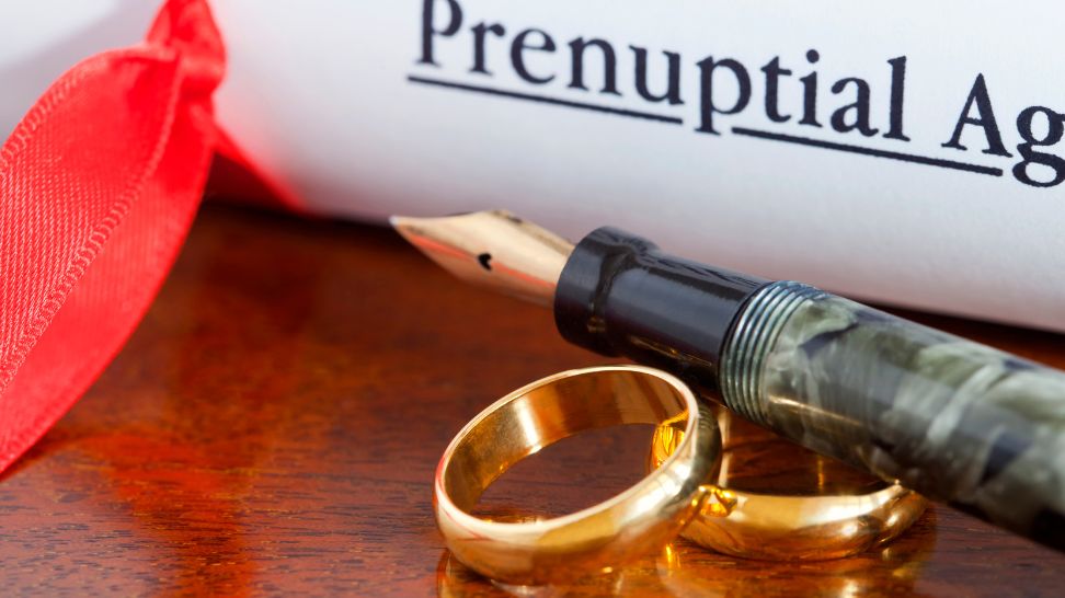prenuptial agreement with ink pen and pair of rings