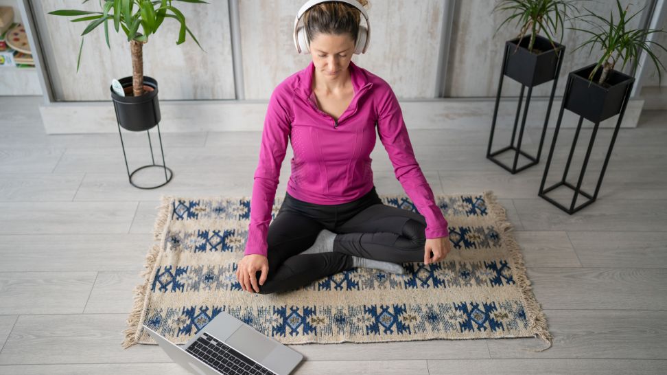 woman doing meditation yoga self care practice at home