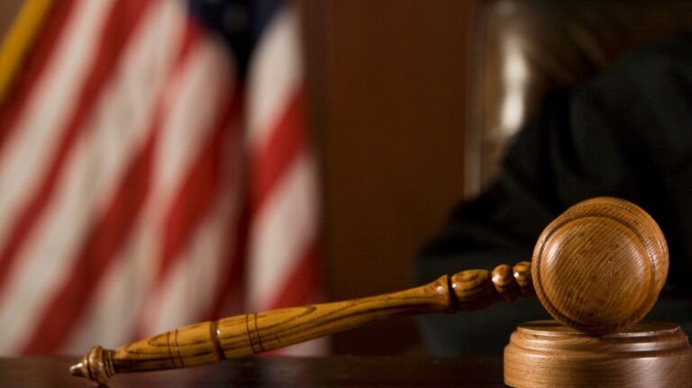 wooden gavel on blurred US flag background