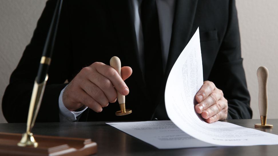 attorney stamping document at table