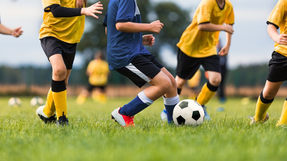 children playing soccer in field