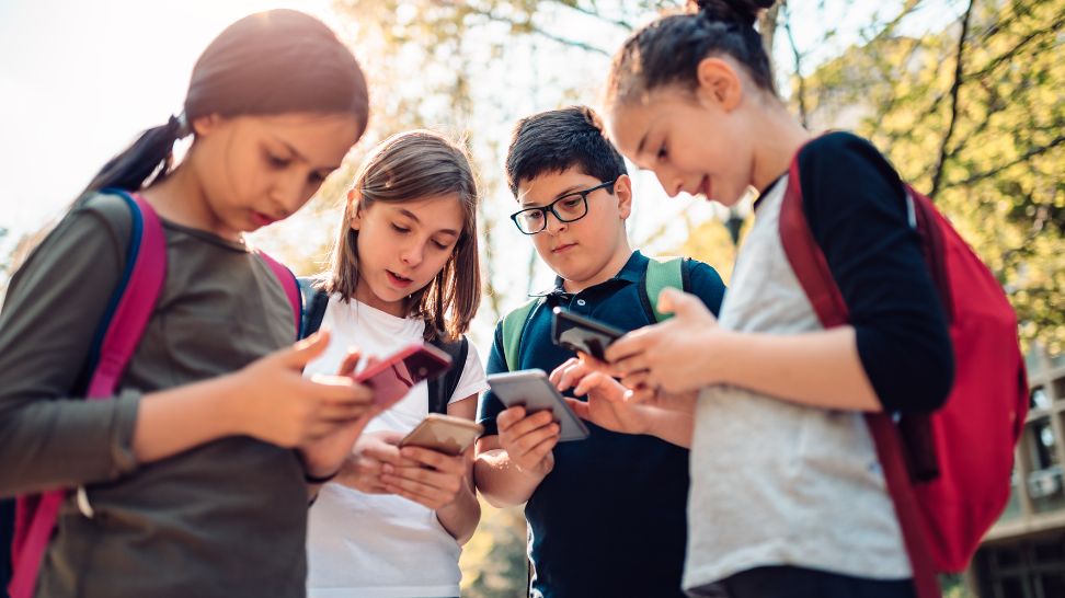 group of school kids using smart phone