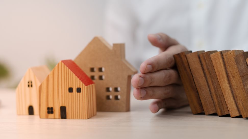 hand protecting house in falling blocks