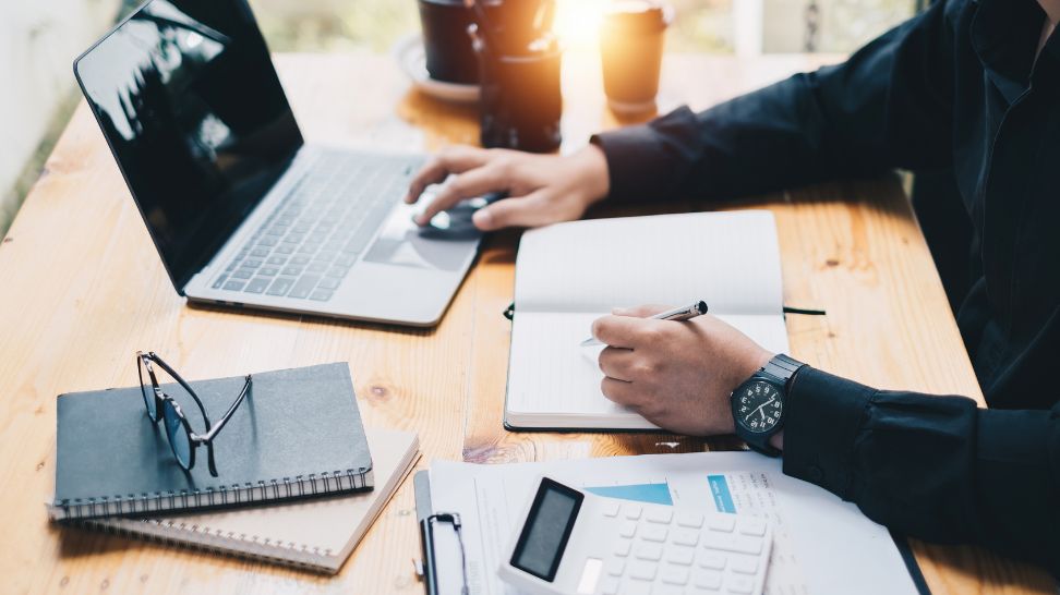 accountant working on laptop notebook and calculator