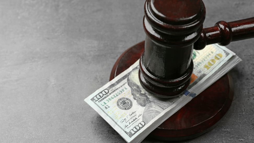 gavel with dollars on grey background