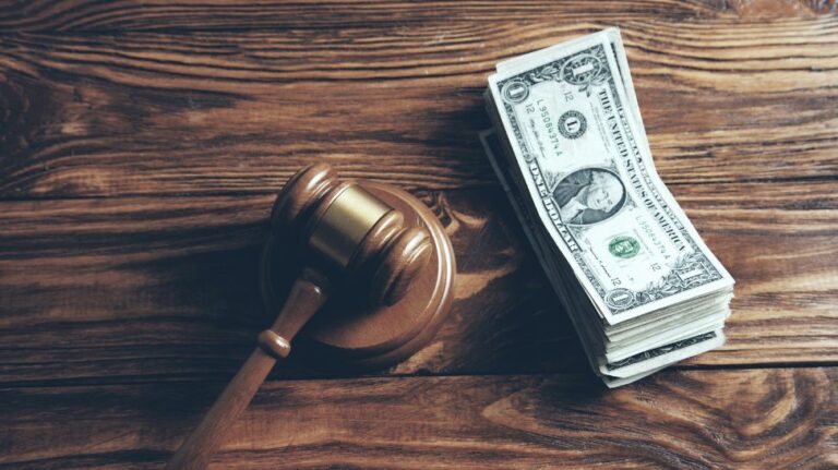 wooden gavel and stack of dollar bills